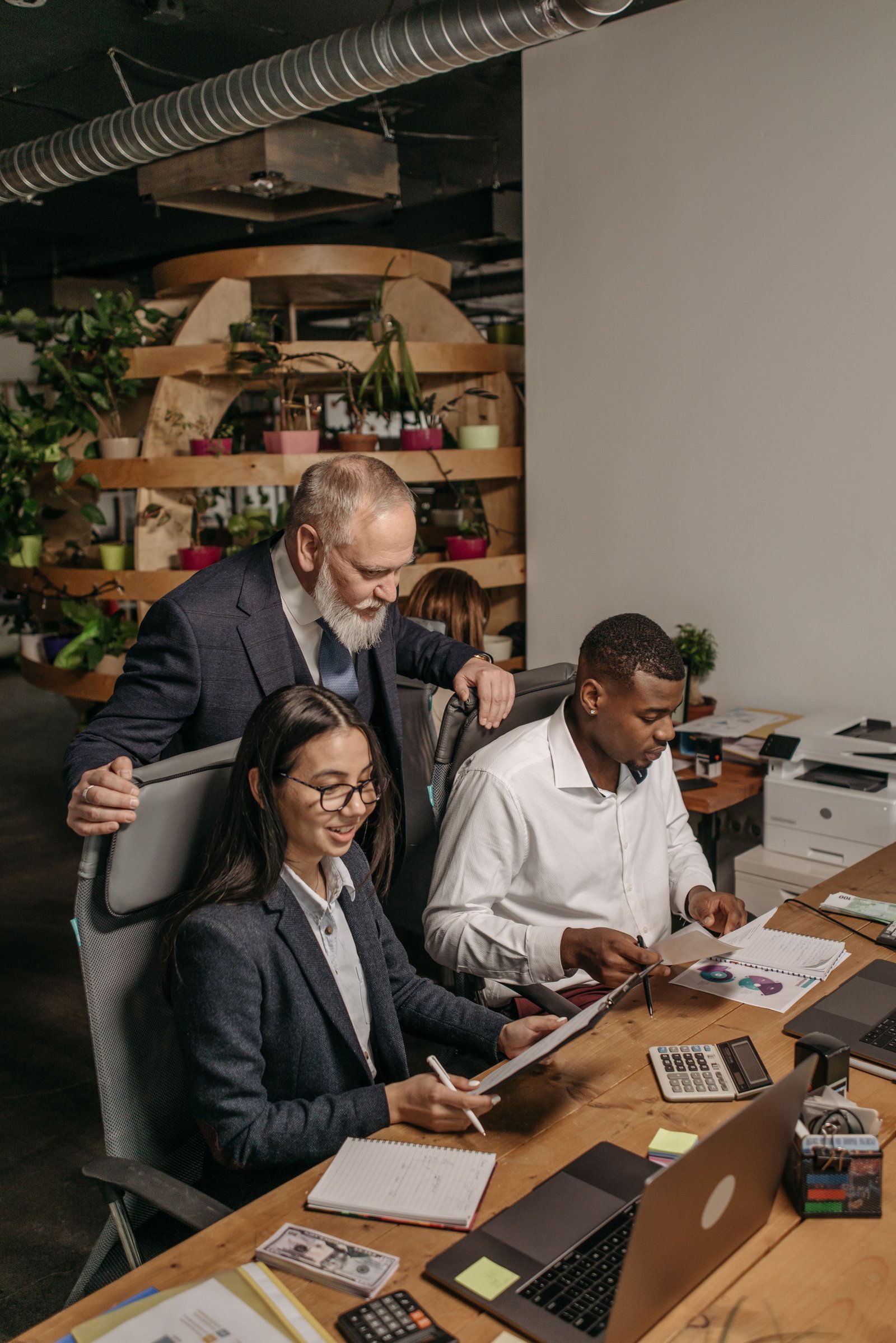 Professional team collaborating in a modern office environment with documents and technology.