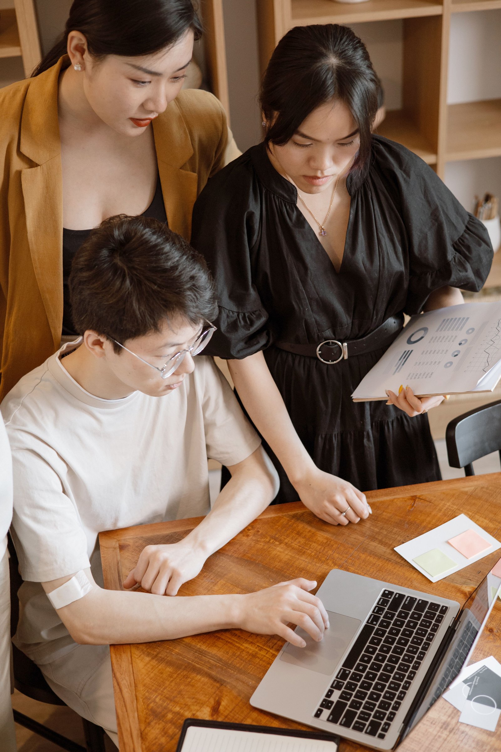 Focused team working together around a laptop during a business meeting.